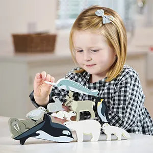 A child playing with wooden stacking polar animals